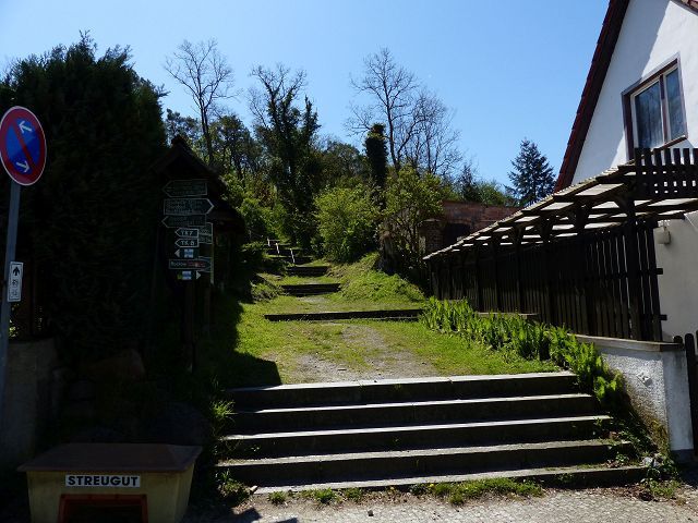 Blick auf Aufstieg zum Luisenberg von der Königstraße aus - Mit Bäumen bewachsene Grünfläche hinter Wohnbebauung ca. 3 Autominuten vom Strandbad Buckow am Schermützelsee entfernt