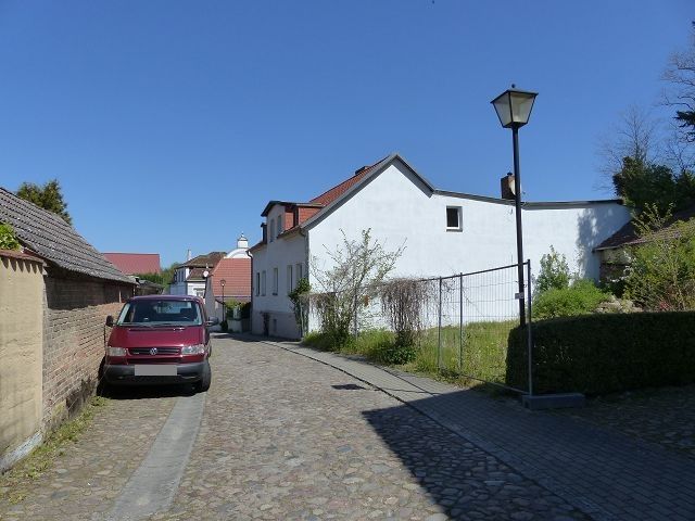 Ansicht Neue Promenade und Nachbarbebauung - Mit Bäumen bewachsene Grünfläche hinter Wohnbebauung ca. 3 Autominuten vom Strandbad Buckow am Schermützelsee entfernt