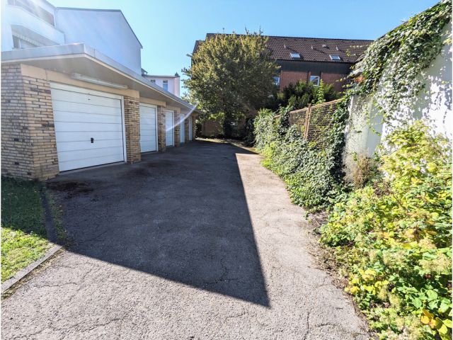 Grundstücksteil vor der den Garagen - Befestigte Zufahrt zwischen Wohnhäusern in einem Wohngebiet