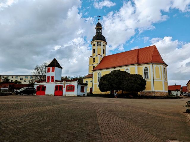 Blick vom Verkaufsgrundstück auf die Umgebung - Teil einer ehemaligen Wassermühle in zentraler Lage am Kirchplatz mit Garagenzeile