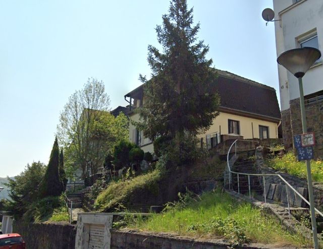 Blick auf die Verkaufsfläche und Umgebung - Kleines Grundstück zwischen Wohnhäusern **teilweise bebaut mit einer Begrenzungsmauer**