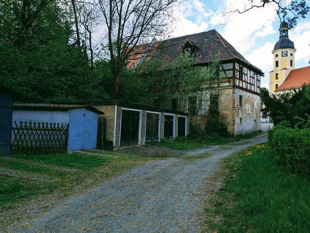 Blick auf Verkaufsobjekt und Umgebung - Garagenzeile und Teil einer ehemaligen Wassermühle in zentraler Lage am Kirchplatz