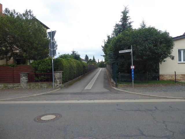 Blick in die Anliegerstraße - Vermietetes Gartengrundstück hinter Wohnbebauung im Harz