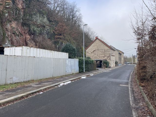 Blick auf die Verkaufsfläche und Umgebung - Vertragsfreier Steilhang (Wald-/Gehölzflächen) hinter Wohnbebauung