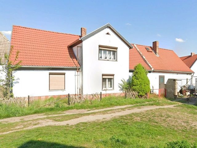 Blick auf Verkaufsobjekt und angrenzende Bebauung - Ruinöse Doppelhaushälfte mit Nebengebäude zwischen Magdeburg und Halle (Saale)