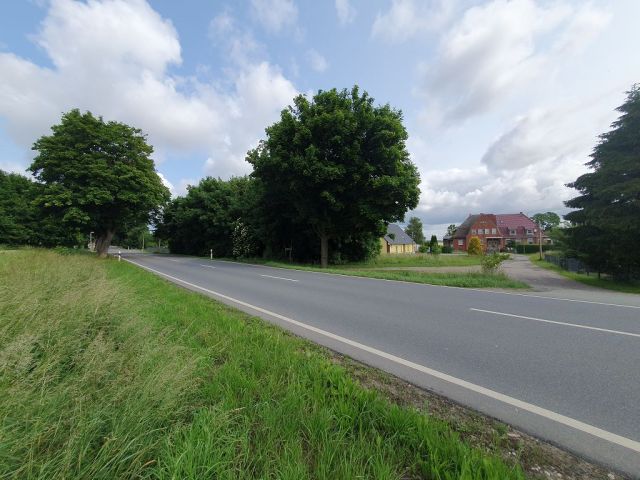 Blick auf Verkaufsfläche, Zufahrt von der Hauptstraße und Umgebung - Grundstück mit Bauvorbescheid für den Neubau eines Wohngebäudes ca. 13 km von der Hansestadt Wismar an der Ostseeküste entfernt