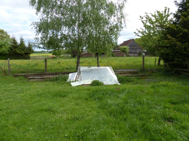 Blick auf Verkaufsfläche und Umgebung - Lagerung von Holzmasten und altem Baumaterial - Vertragslos als Weideland genutzte Grünfläche im Randbereich einer Wohnsiedlung in Meyenburg in der Prignitz