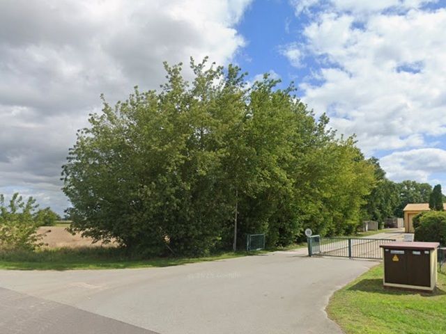 Blick von der B102 auf Verkaufsgegenstand und Umgebung - Bis 30.09.2028 verpachtete Fläche hinter gewerblich genutzten Grundstücken