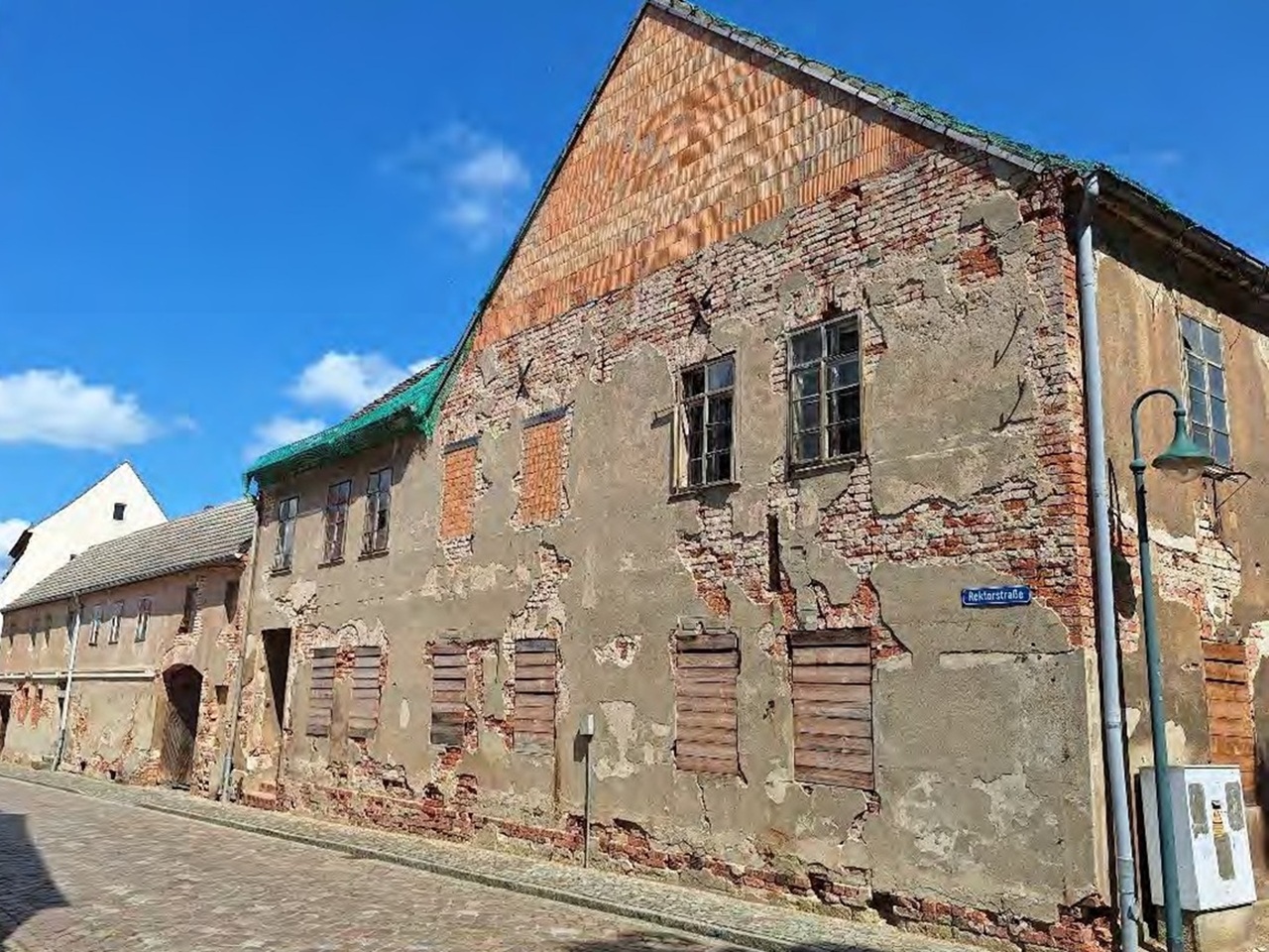 Denkmalgeschütztes, ruinöses Wohn- und Geschäftshaus mit Nebengebäuden gegenüber der Stadtkirche St. Marien