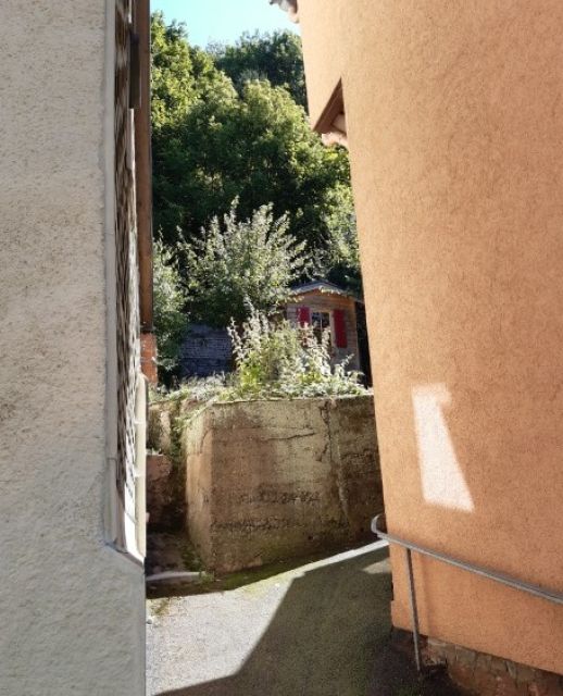 Blick auf die von der Ortsstraße abzweigende Zuwegung und auf die untere Teilfläche des Verkaufsgegenstandes - Gartengrundstück mit kleinem Holzgartenhäuschen im Erholungsort Kleinschmalkalden im Thüringer Wald ** lt. FNP Mischgebiet
