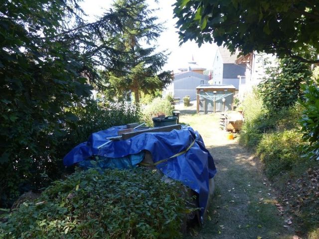 Blick auf den Verkaufsgegenstand - Überwiegend vertragslos genutztes Grundstück vor einem Wohnhaus am östlichen Ortsrand