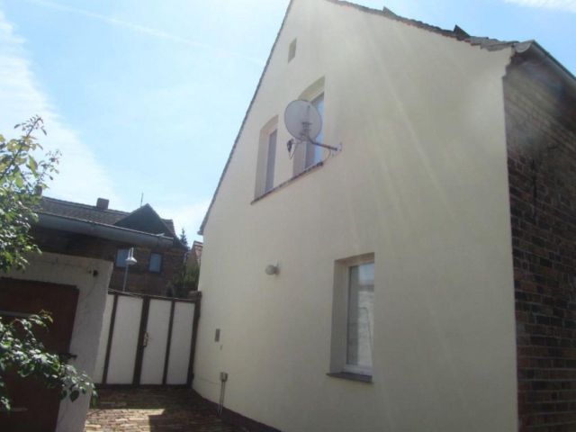 Blick vom Hof auf das Tor und die östliche Giebelwand des Hauses - Leerstehendes Wohnhaus mit Nebengebäude, Garage und Garten in der Goitzsche‑Seenlandschaft +Natur pur vor der Haustür+