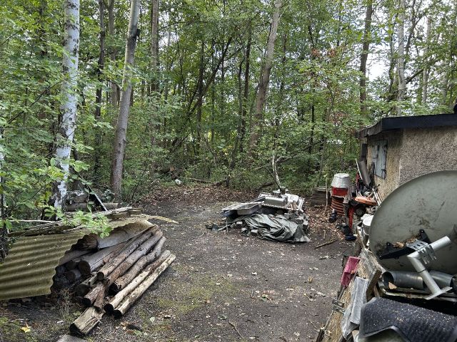 Blick auf Ablagerungen auf der Verkaufsfläche und Nachbargrundstück - Innenbereichsgrundstück mit Garage in ruhiger Wohnlage im Lausitzer Seenland